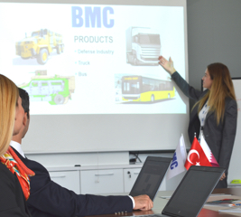 A woman is making a presentation, a group of people looking at her