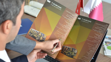 Bir kadın bir adama BMC kataloğundan bir şey gösteriyor.